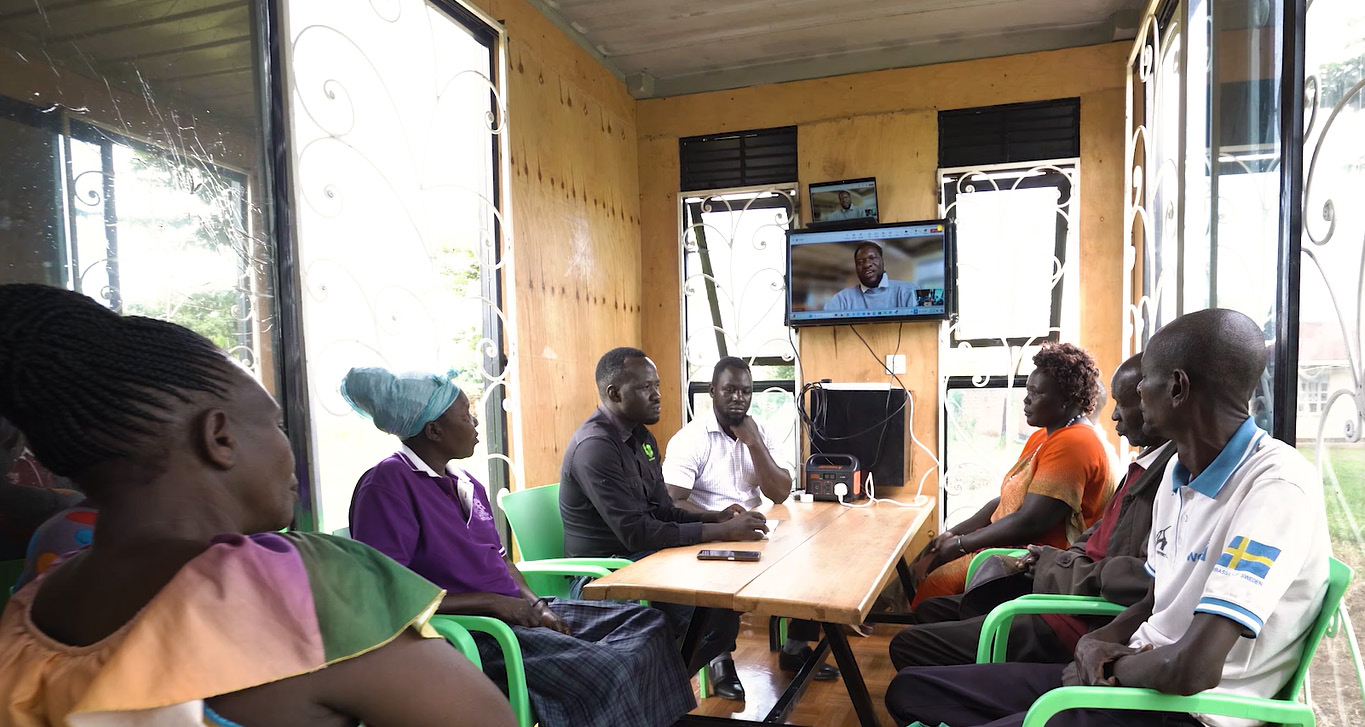 Community members in the law box listening to the lawyer on the tv screen