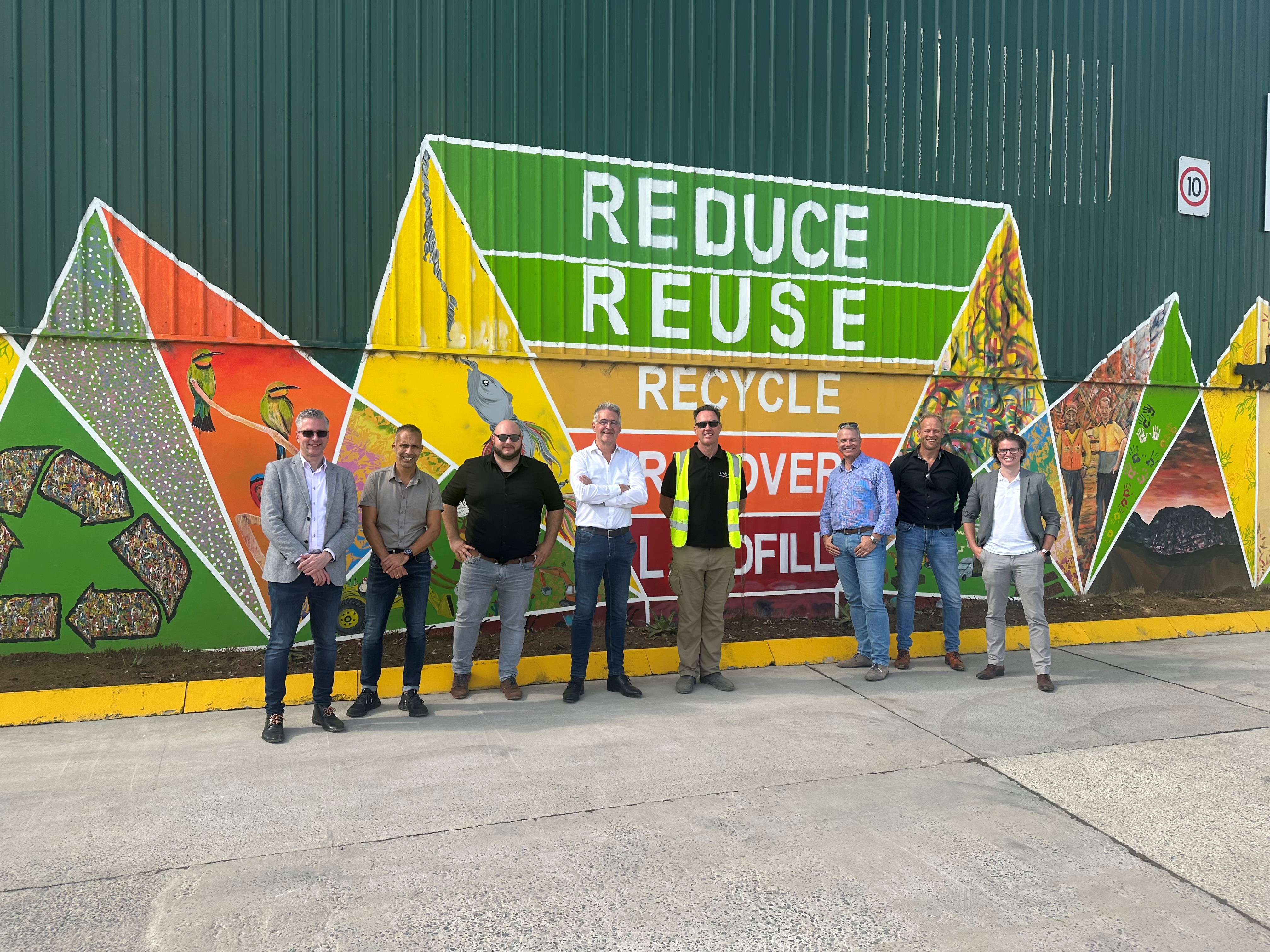 PIB Cluster on Waste and Circularity in front of mural reading "reduce, reuse, recycle"