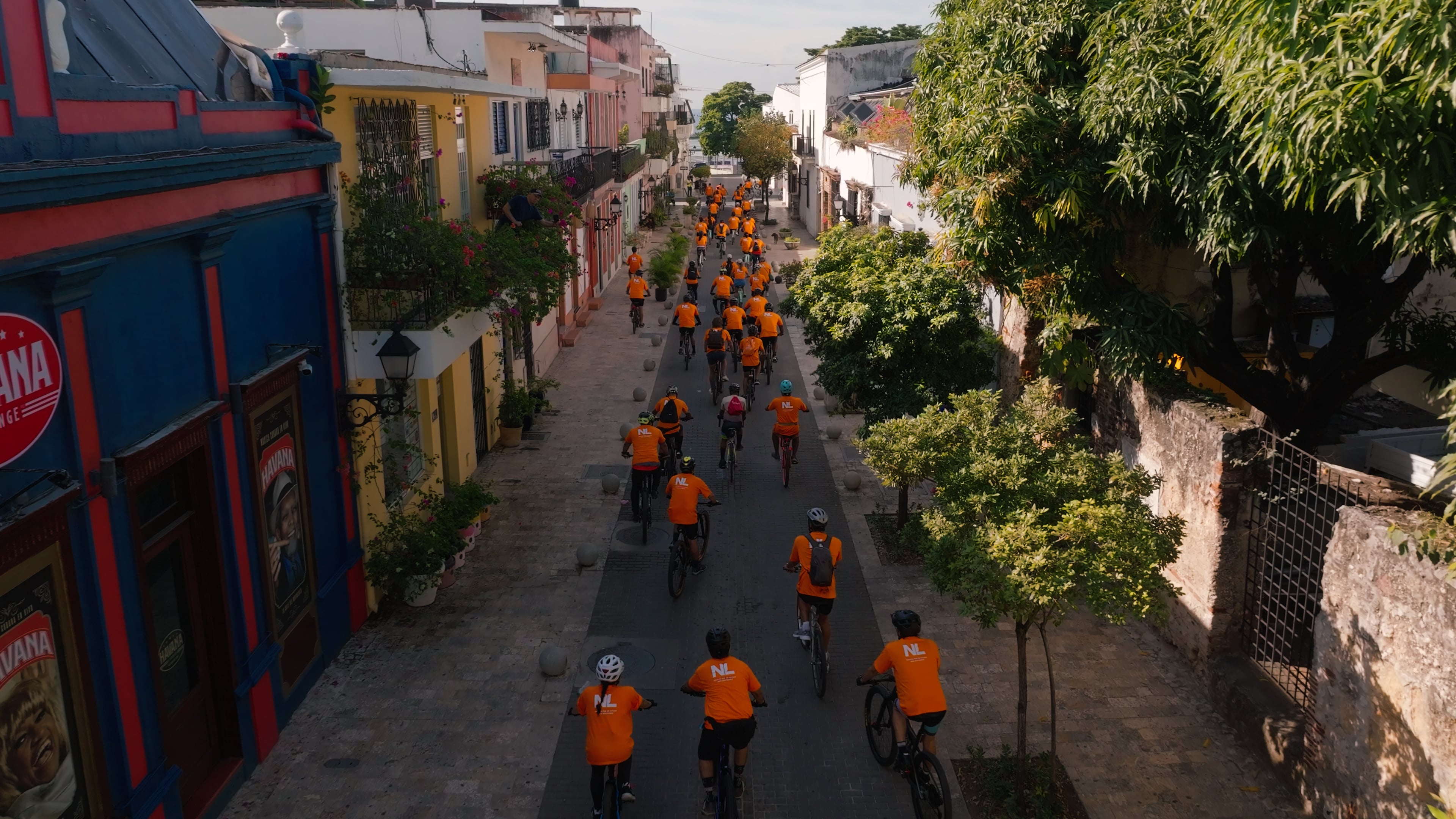 people on bicicles with orange t-shirts on in the dominican republic