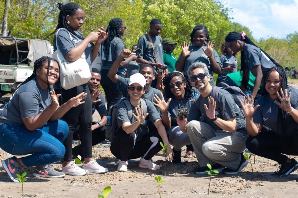 Youth showing dirty hands after panting mangrove trees