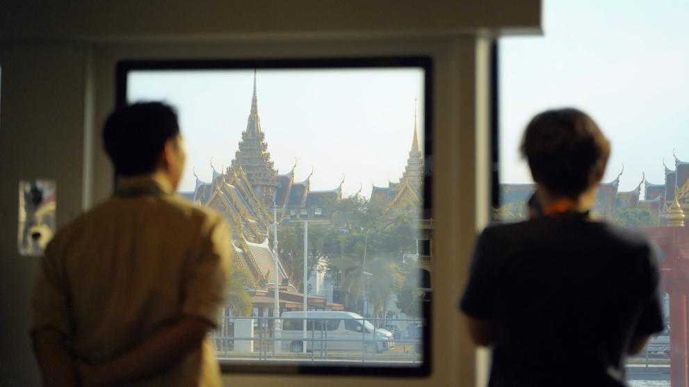 Two men looking out the window at a temple in Bangkok